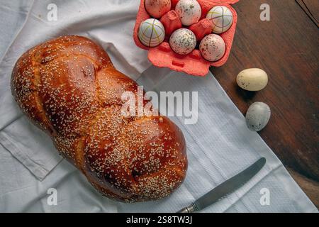 Süßes Osterbrot, hausgemachte Toureki-Zöpfe und Ostereier auf einem weißen Tuch auf dem Holztisch, Blick von oben Stockfoto