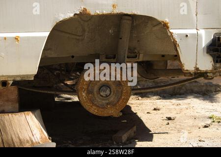 Nahaufnahme des hinteren Abschnitts eines Fahrzeugs mit rostfreier Trommelbremse und korrodiertem Laufwerk. Stockfoto