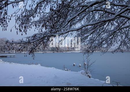 Die Schönheit eines Wintertages zeigt sich in diesem Bild des Bernardiner Sees in Trakai, Litauen. Die Sonne scheint hell über dem Kopf und wirft einen warmen Glo Stockfoto