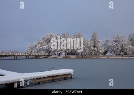 Die Schönheit eines Wintertages zeigt sich in diesem Bild des Galve-Sees in Trakai, Litauen. Die Sonne scheint hell über dem Himmel und strahlt ein warmes Leuchten aus Stockfoto