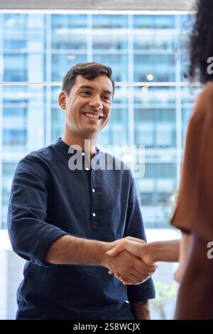 Handschlag eines glücklichen Geschäftsmannes und einer Geschäftsfrau, die sich im Büro treffen. Stockfoto