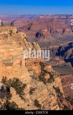Ein wunderschöner Blick auf den Grand Canyon mit einem Mann, der auf einem Felsvorsprung steht. Der Mann blickt über den Canyon und genießt die atemberaubende Landschaft Stockfoto