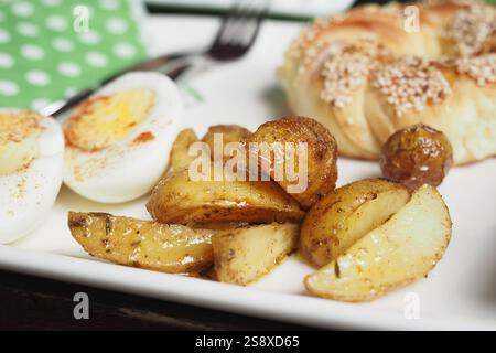 Ein unglaublich leckerer Frühstücksteller mit Eiern, Kartoffeln und Gebäck Stockfoto