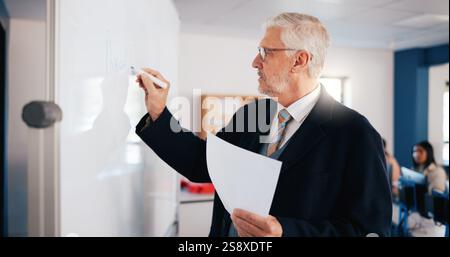 Reifer Mann, Dozent und Schreiben mit Whiteboard im Unterricht für Physikunterricht, Unterricht oder Einführung. Männlicher Mensch, Professor oder Lehrer mit Stockfoto