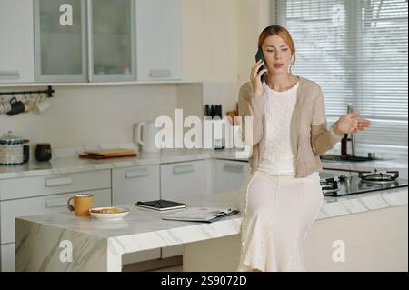 Tagsüber telefonieren in der modernen Küche Stockfoto