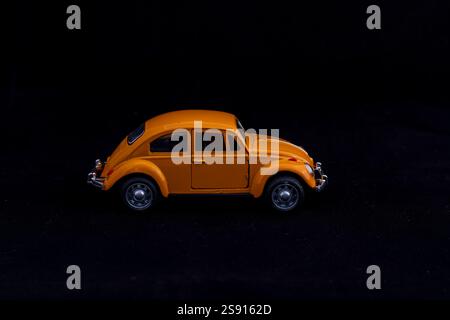 Classic Yellow Beetle Model Car Seitenansicht auf schwarzem Hintergrund Stockfoto