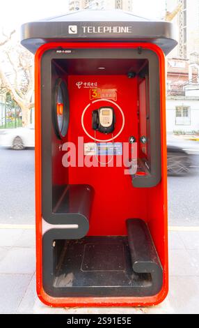 Shanghai, China. Januar 2025. Die rote Telefonzelle auf einem Bürgersteig im Stadtzentrum Stockfoto