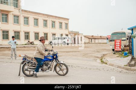 Tibetischer Mann auf Motorrad in der Nähe des Qinghai-Sees auf dem tibetischen Plateau in der Provinz Qinghai, China Stockfoto