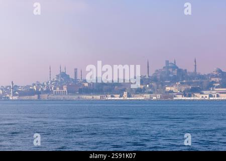 Malerischer Blick auf Istanbuls historische Halbinsel vom Meer aus. Die Blaue Moschee, die Hagia Sophia und der Topkapi Palast stehen vor einem trüben Himmel. Stockfoto