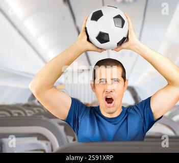 Fan Sport Spieler auf blauer Uniform feiert mit Fußball oder Fußball im Flugzeug Stockfoto