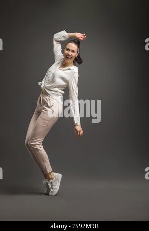 Junge und Schoene Taenzerin posiert im Studio vor farbigem Hintergrund Stockfoto