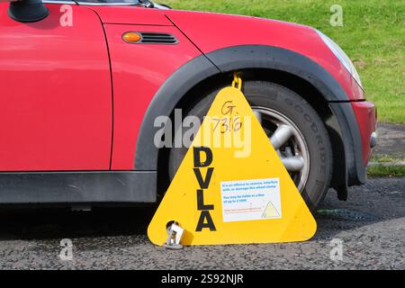 DVLA-Radklemme an einem nicht besteuerten Auto, das auf einer Straße in England geparkt ist Stockfoto