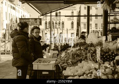 VENEDIG, ITALIEN - 16. FEBRUAR 2015: Seniorin kauft Obst und Gemüse auf dem Rialto-Markt. Historisches Foto von Sepia Stockfoto