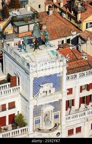 Markusuhr mit geflügeltem Löwen, Glocke und Madonna mit Kind. Blick vom Campanile-Turm auf der Piazza San Marco in Venedig, Italien. Stockfoto