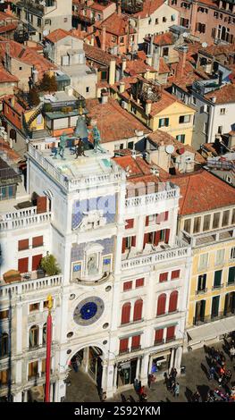 Markusuhr mit geflügeltem Löwen, Glocke und Madonna mit Kind. Blick vom Campanile-Turm auf der Piazza San Marco in Venedig, Italien. Stockfoto