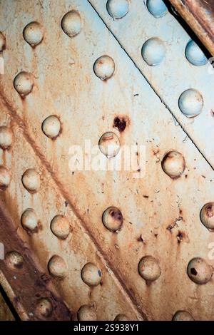 Das Bild zeigt eine rostfreie Metalloberfläche mit vielen kleinen Löchern. Die Löcher sind über die gesamte Oberfläche verstreut, und das Metall scheint alt und abgenutzt zu sein. Stockfoto