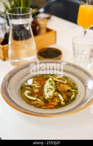 Ein perfekt gegrilltes Lachsfilet, serviert mit geröstetem Gemüse und einer cremigen Sauce auf einem dekorativen Teller. Das Gericht wird mit Spinatblättern garniert. Stockfoto