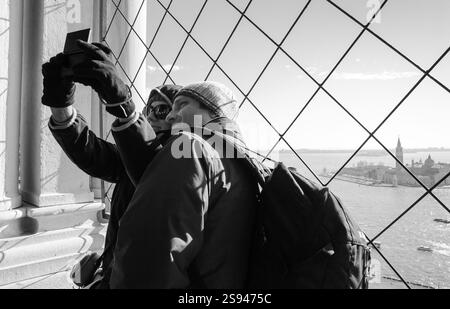 VENEDIG, ITALIEN - 16. FEBRUAR 2015: Unbekannte Touristen machen Selfie vom Campanile-Turm auf dem Markusplatz während der Karnew Stockfoto