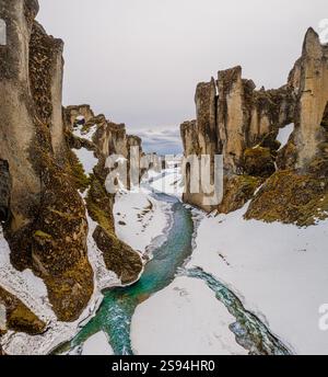 Schneebedeckter Fjaðrárgljúfur Canyon mit einem sich windenden Fluss, Südisland. Stockfoto