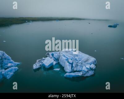 Aus der Vogelperspektive der riesigen Eisberge, die in den ruhigen Gewässern von Jökulsárlón, Südisland, schwimmen Stockfoto