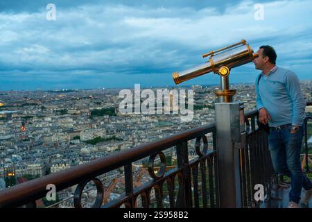 Paris, Frankreich - Touristen blicken nachts vom Eiffelturm über Paris, wenn die Gebäude beleuchtet werden. Stockfoto