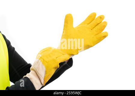 Nahaufnahme eines erwachsenen männlichen Konstrukteurs, der industrielle Arbeitshandschuhe anzieht, als Vorbereitung auf die Arbeit isoliert auf weißem Atelierhintergrund Stockfoto