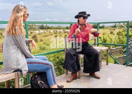 Das Cowgirl des Schutzes erklärt auf einem Wagen den Ranchprozess in Laurent Manade, Camargue, Provence, Frankreich, Europa Stockfoto