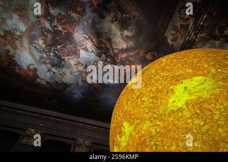 London, Großbritannien. Januar 2025. „Helios“, eine neue Kunstinstallation der Sonne von Luke Jerram in der Painted Hall, Old Royal Naval College, Greenwich. Im Maßstab von 1:200 Millionen kombiniert die innen beleuchtete sieben Meter große Skulptur Sonnenbilder, Licht und Ton, um die komplizierten Details der Sonne hervorzuheben. Benannt nach dem antiken griechischen und römischen Sonnengott, symbolisch für Zeit und Leben, würdigt „Helios“ den tiefgreifenden Einfluss der Sonne auf die menschliche Geschichte und Kultur. Guy Corbishley/Alamy Live News Stockfoto