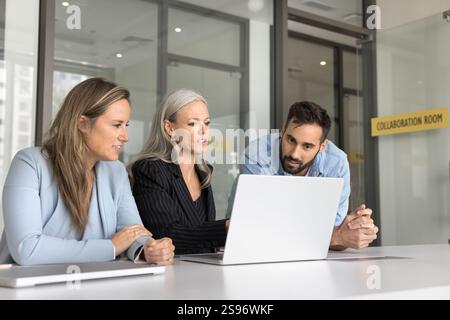 Drei verschiedene Teamkollegen verwenden Notebooks am Arbeitsplatz Stockfoto