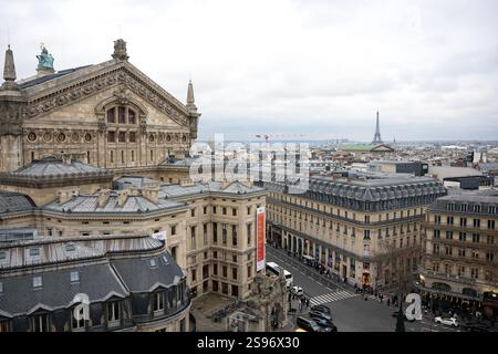 Paris, Frankreich 01.24.2025. Ein atemberaubender Blick auf die Pariser Architektur mit der historischen Oper Garnier, klassischen Dächern und dem Eiffelturm unter bewölktem Himmel. Stockfoto