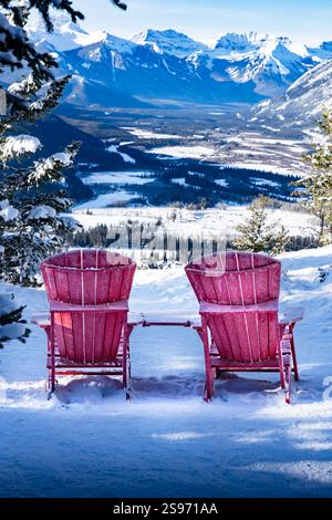 Parkstühle mit Blick auf den Banff National Park Tunnel Mountain View im Winter in der Nähe von Skigebieten und Touristenattraktionen. Stockfoto