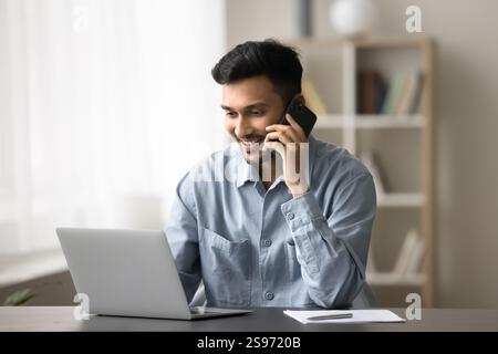 Junger Geschäftsmann berät den Kunden telefonisch auf dem Notebook-Bildschirm Stockfoto