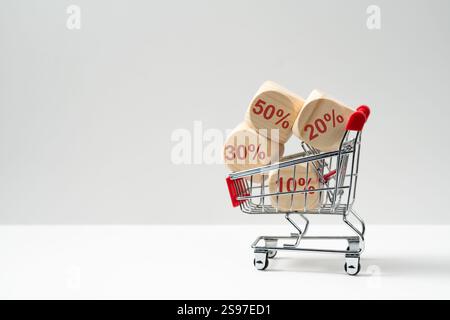 Holzwürfel mit Symbolen für Rabattprozentsatz im Warenkorb, Konzept des Online-Einkaufs, des Verkaufs, der Promotion, des Rabatts oder des Schnäppchens Stockfoto