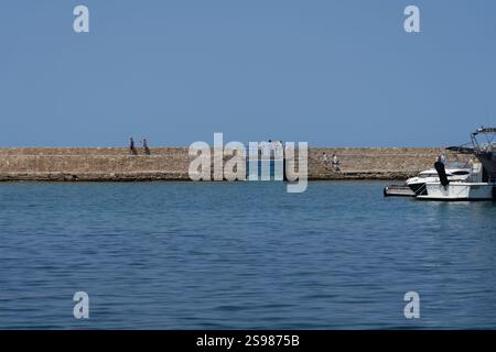 Chania - Kreta - 17. August 2024; Menschen auf einem Wellengang über den Hafen an einem wunderschönen mediterranen Tag. Stockfoto