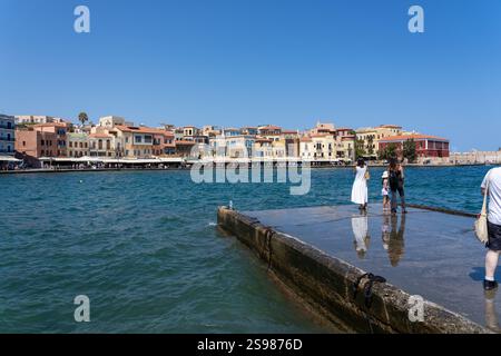 Chania - Kreta - 17. August 2024; zwei Frauen und ein Kind Touristen stehen im Hafen und blicken über den Hafen zu den Gebäuden und der Promenade von Kountourioti Stockfoto