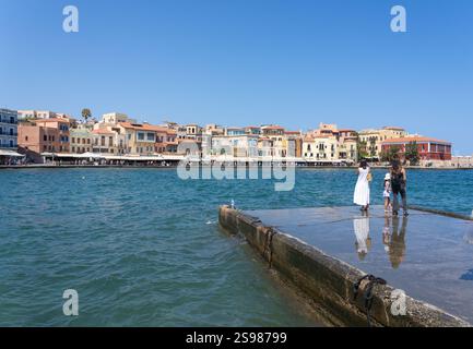 Chania - Kreta - 17. August 2024; zwei Frauen und ein Kind Touristen stehen im Hafen und blicken über den Hafen zu den Gebäuden und der Promenade von Kountourioti Stockfoto