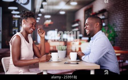 Lachende Männer Und Frauen Sitzen Im Café, Trinken Kaffee Und Reden Stockfoto