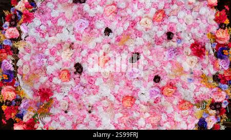 Leuchtende Blumenkomposition mit gemischten, mehrfarbigen Blütenblättern und Rosen in voller Blüte Stockfoto