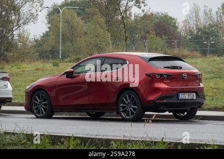 OSTRAVA, TSCHECHIEN - 10. OKTOBER 2023: Roter Mazda 3 (BP, 4. Generation) in Fließheck-Version auf der Straße mit Alufelgen geparkt Stockfoto