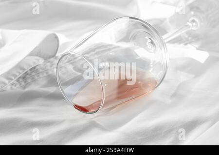 Glas, mit rosafarbenem Wein, verschüttet auf einem weißen Hemd, Nahaufnahme, selektiver Fokus, keine Leute, Konzept, Draufsicht Stockfoto