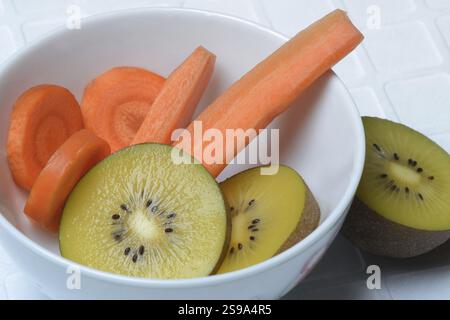 Karottenscheiben und Kiwischeiben in Schale, Kiwifrucht und Karotte Stockfoto