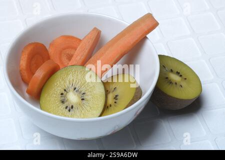Karottenscheiben und Kiwischeiben in Schale, Kiwifrucht und Karotte Stockfoto