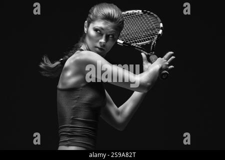 Tennisspielerin mit Schläger hinter dem Kopf, vor schwarzem Hintergrund, Kemerowo, Russland, Europa Stockfoto