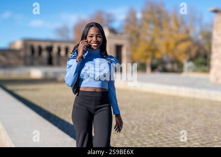 Junge Berufsfrau, die in der Stadt unterwegs ist und mit dem Handy spricht Stockfoto