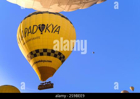 GOREME, TÜRKEI - 4. OKTOBER 2020: Es ist ein Ballon, der in einer Gruppe anderer Ballons am Morgenhimmel Kappadokiens schwebt. Stockfoto