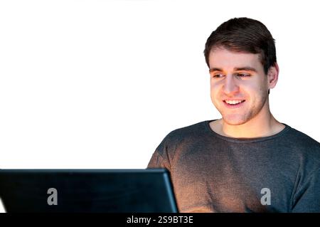 Kopf- und Schulteransicht eines lächelnden jungen Mannes, der vor einem abgeschnittenen Notizbuch sitzt, isoliert auf weiß. Stockfoto