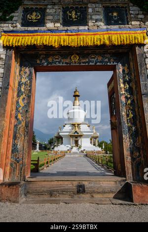 Weiß getünchte National Memorial Chorten glänzt im Sonnenlicht durch den farbenfrohen Eingangsweg, Thimphu, Bhutan Stockfoto