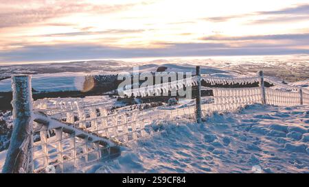 Moel Famau im Schnee bietet eisige Zäune, gefrorene Gräser und klaren blauen Himmel. Ein atemberaubendes Winterwunderland in Wales, perfekt für Wanderer und Fotografen Stockfoto