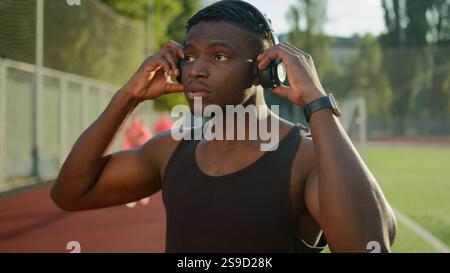 Afroamerikanischer Hipster-Mann Sportsman Runner Tragen Kopfhörer Hören Sie Musik-Playlist auf Smartwatch, um im Freien männlichen Athleten sportlich Guy zu trainieren Stockfoto