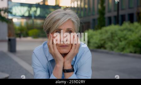 Verärgert nachdenklich traurig besorgte alte Frau kaukasische Senior Geschäftsfrau denkt Trauergedanken reife Dame denkt im Freien, Sorgen Karrierescheitern Stockfoto